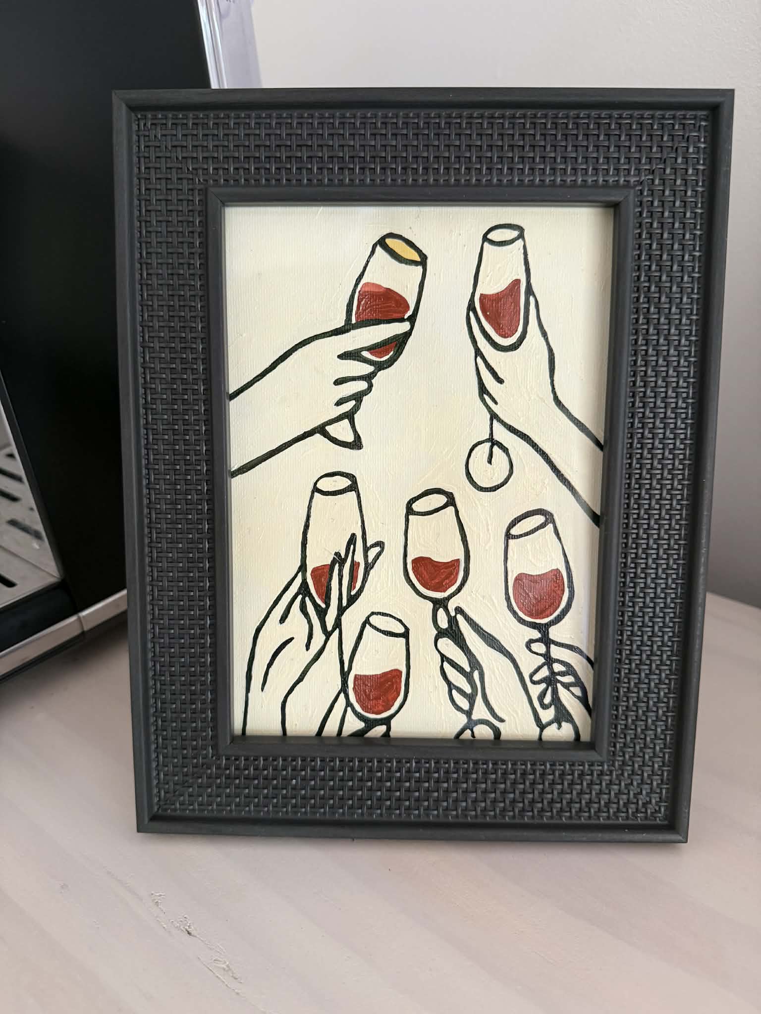 Framed painting of hands raising wine glasses in a toast